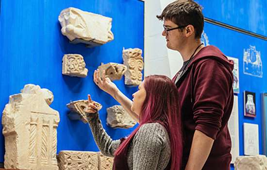 Two visitors engage with objects on display at St Augustine's Abbey