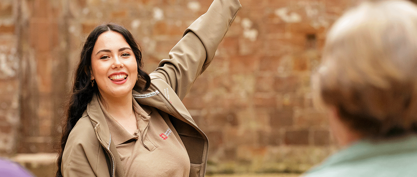 Photo of an English Heritage tour guide pointing out a feature at Kenilworth Castle and Elizabethan Garden